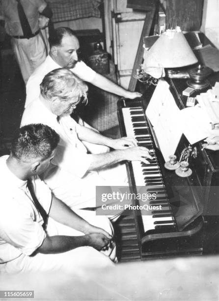 German-born French medical missionary and theologian Dr. Albert Schweitzer plays the piano at his home as unidentified other listen, Lambarene,...