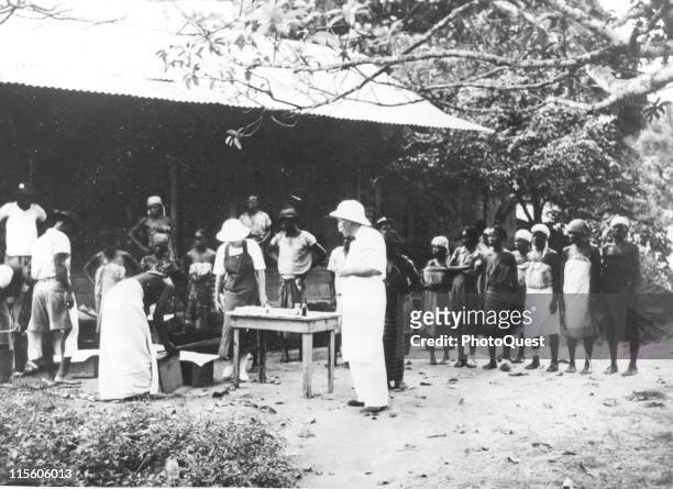 German-born French medical missionary and theologian Dr. Albert Schweitzer stands with his patients at an open-air clinic near his home, Lambarene,...