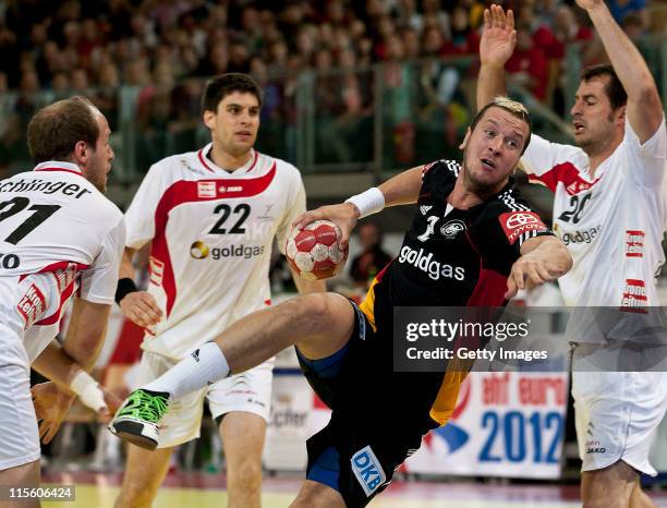 Pascal Hens of Germany is challenged by Roland Schlinger of Austria during the Euro 2012 qualifier match between Austria and Germany at Olympiahalle...