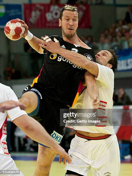 Pascal Hens of Germany is challenged by Viktor Szilagyi of Austria during the Euro 2012 qualifier match between Austria and Germany at Olympiahalle...