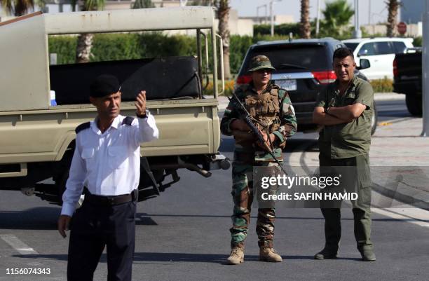 Iraqi Kurdish security stand guard outside the restaurant where two people were shot dead in Arbil, the capital of northern Iraq's Kurdish autonomous...