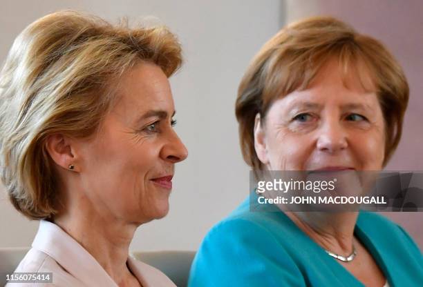 Newly elected European Commission President and outgoing German Defence Minister Ursula von der Leyen sits next to German Chancellor Angela Merkel...