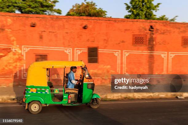 indian man drives auto rickshaw (tuk-tuk), india - auto rickshaw stock pictures, royalty-free photos & images