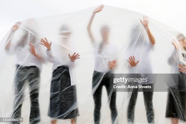 silhouettes of people in black and white clothes behind a translucent veil - suffocated stock-fotos und bilder