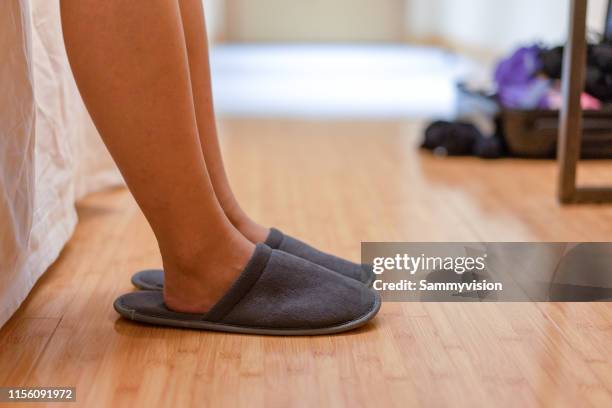 low section of woman wearing slippers on hardwood floor at bedroom - human foot stock pictures, royalty-free photos & images