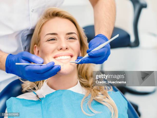 woman having teeth examined at dentists - smiling dentist stock pictures, royalty-free photos & images