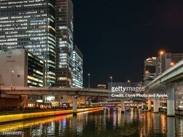 night view of downtown osaka along the dojima river - 大阪府 stockfoto's en -beelden