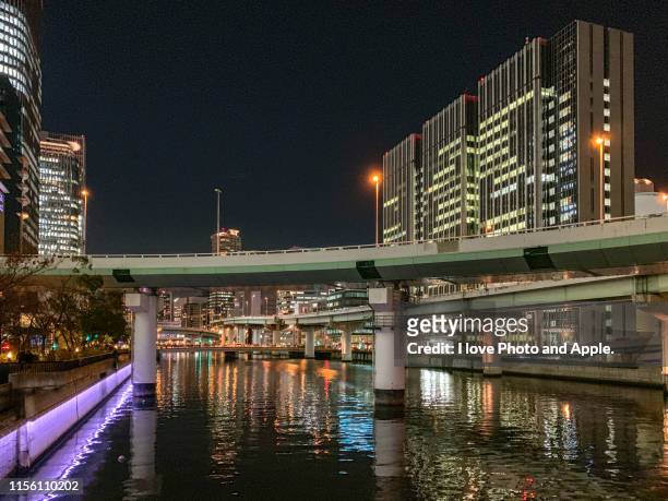 night view of downtown osaka along the dojima river - 大阪市 stock-fotos und bilder