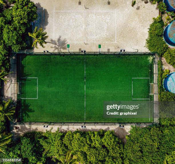 aerial soccer court between the trees in the tropical island - grass court stock-fotos und bilder