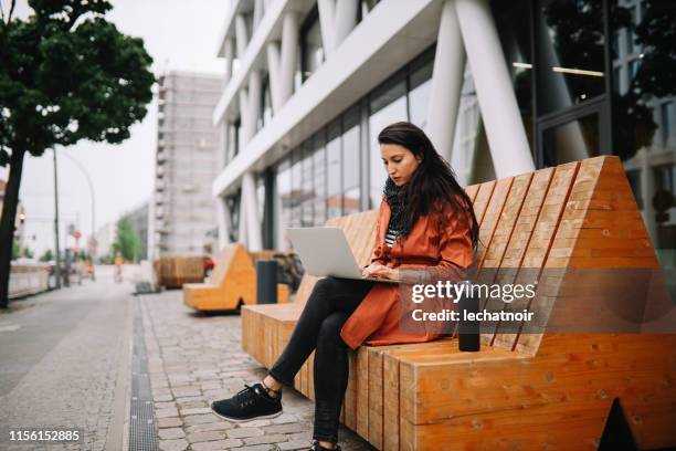 junge frau arbeitet unterwegs in berlin - arbeiten outdoor stadt laptop stock-fotos und bilder