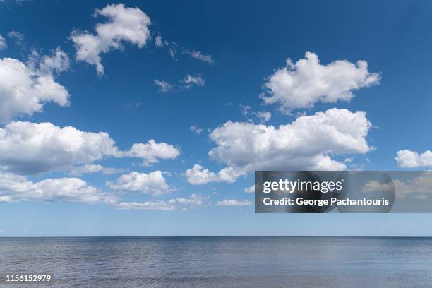 beautiful clouds over calm sea - cumulus stockfoto's en -beelden