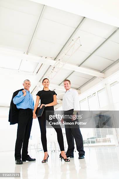 business team in bright office - group of businesspeople standing low angle view stock pictures, royalty-free photos & images
