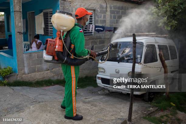 Personnel of the Health Minister of Dominican Republic fumigates between houses at the Santo Domingo's neighborhood Pantoja to fight dengue fever, on...