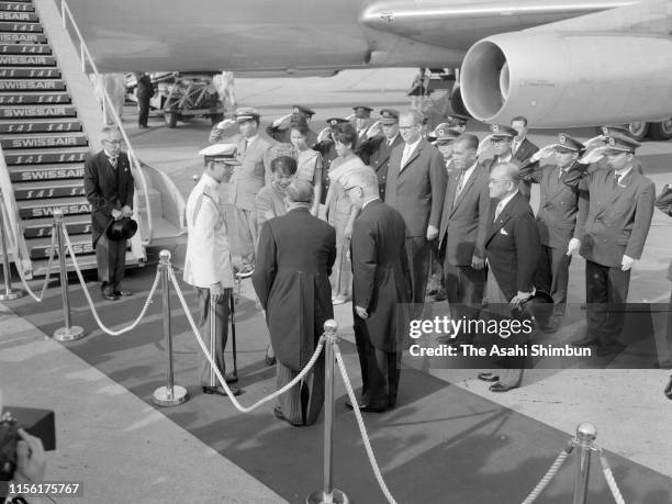 King Bhumibol and Queen Sirikit of Thailand are welcomed by Emperor Hirohito and Empress Nagako on arrival at Haneda Airport on May 27, 1963 in...