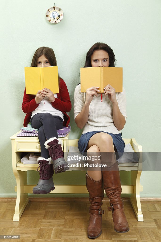 Portrait of mother and daughter reading