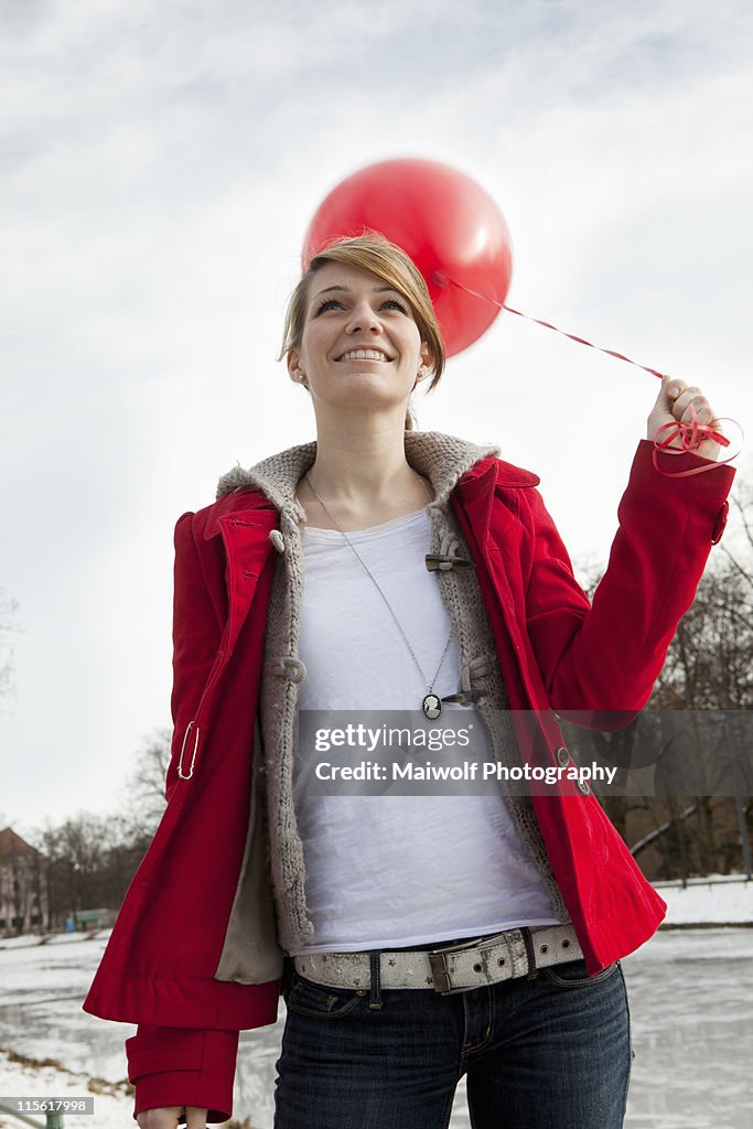 Young woman holding red ballon