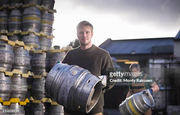 workers with barrels outside brewery - bier brouwen stockfoto's en -beelden