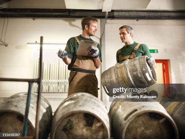 workers in brewery with barrels - bierfass stock-fotos und bilder
