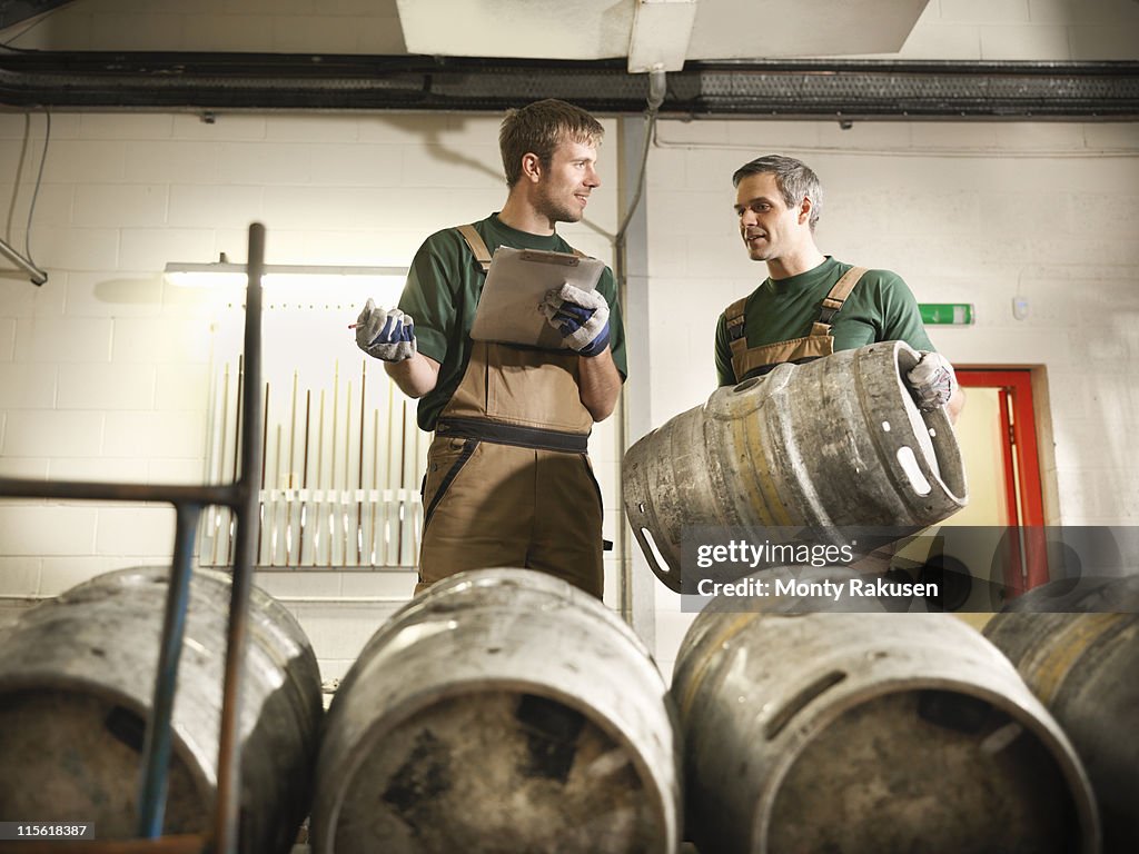 Workers in brewery with barrels