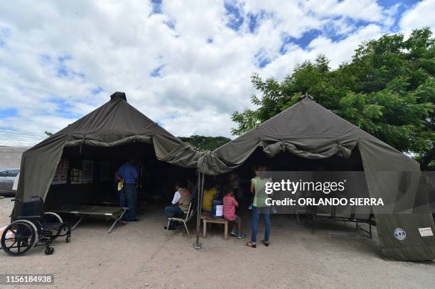 Patients infected with dengue, which vector is the Aedes aegypti, wait to be assisted under an improvised tent at the Roberto Suazo Cordova Hospital,...