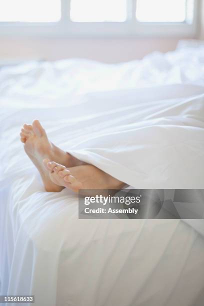 woman's feet on end of bed - lower bildbanksfoton och bilder