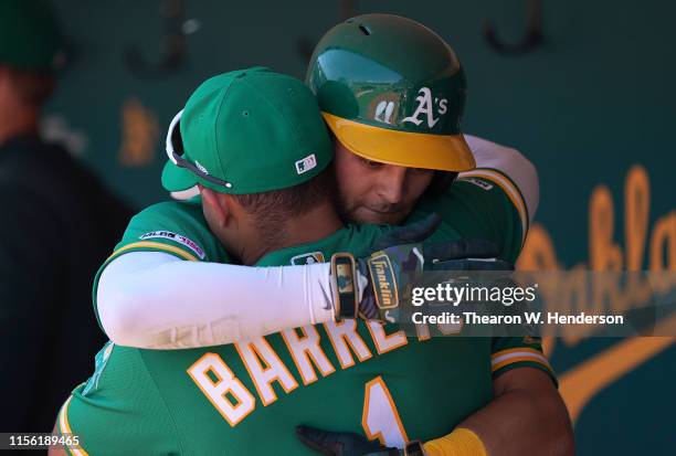 Chad Pinder of the Oakland Athletics is greated with a hug in the dugout by Franklin Barreto after Pinder hit a three-run home run against the...