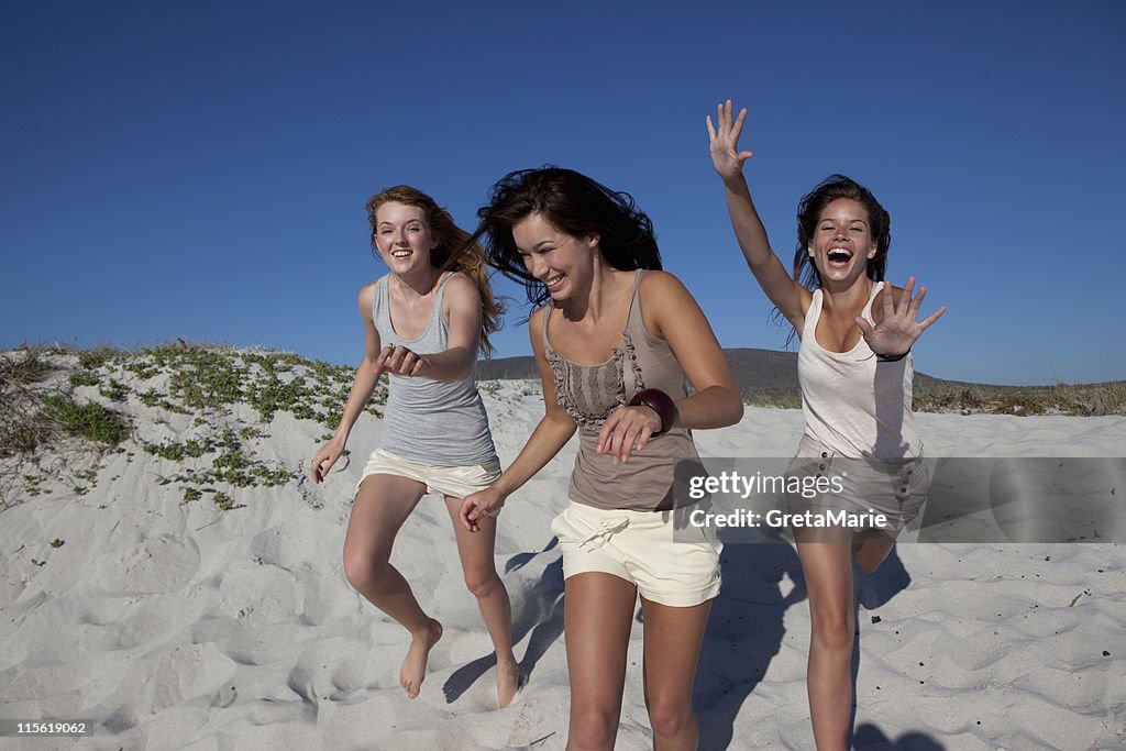 Three girls running towards camera