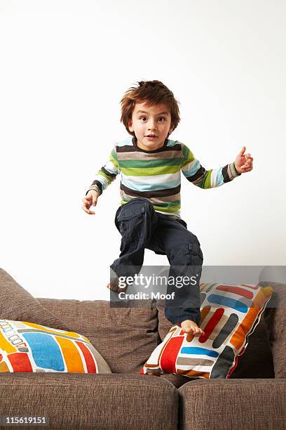 boy jumping on sofa - boys jumping stock pictures, royalty-free photos & images