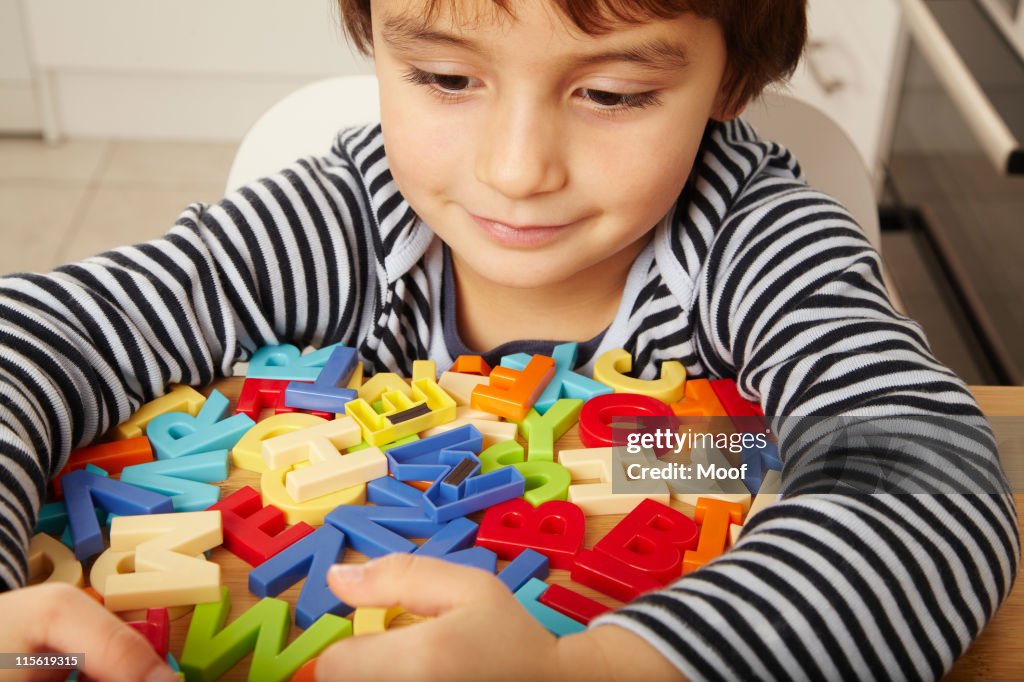 Boy playing with letters in kitchen