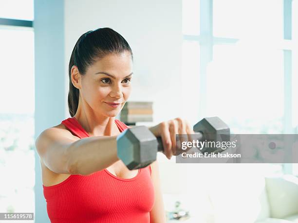 mixed race woman exercising with dumbbells - hand weight - fotografias e filmes do acervo