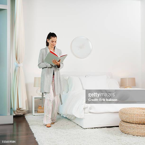 mixed race woman reading book in bedroom - look down - fotografias e filmes do acervo