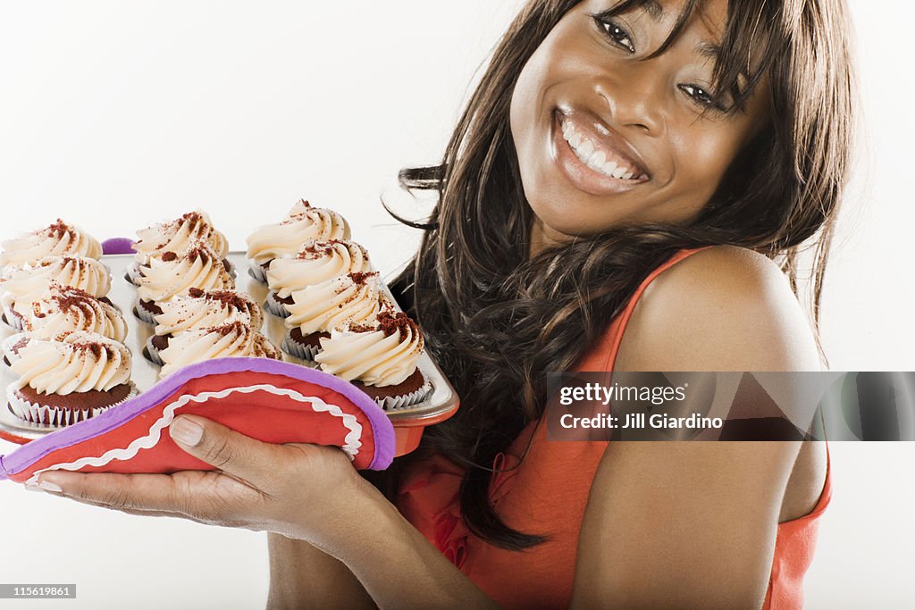 African American woman holding cupcakes