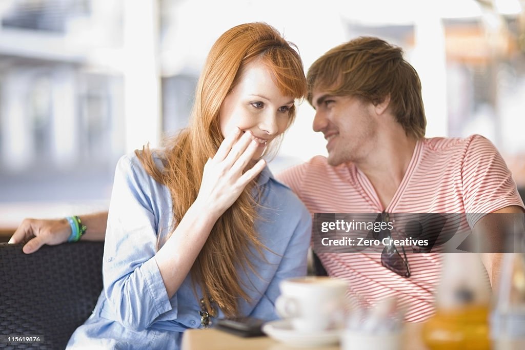 Young laughing couple having some coffee