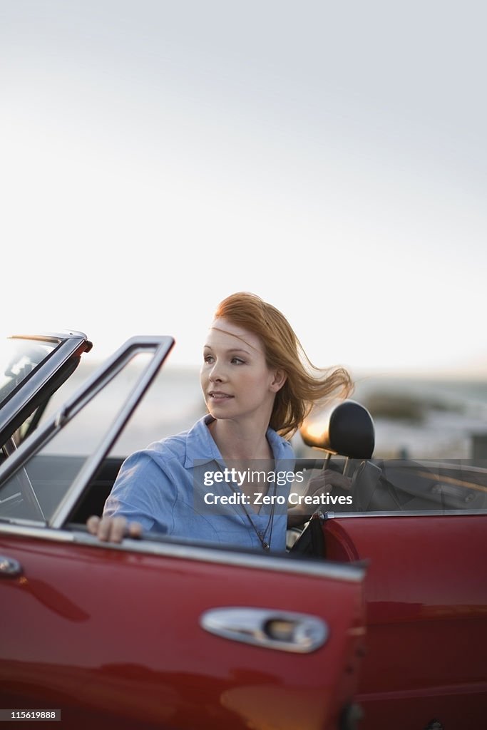 Jeune fille aux cheveux rouge dans le salon rouge voiture