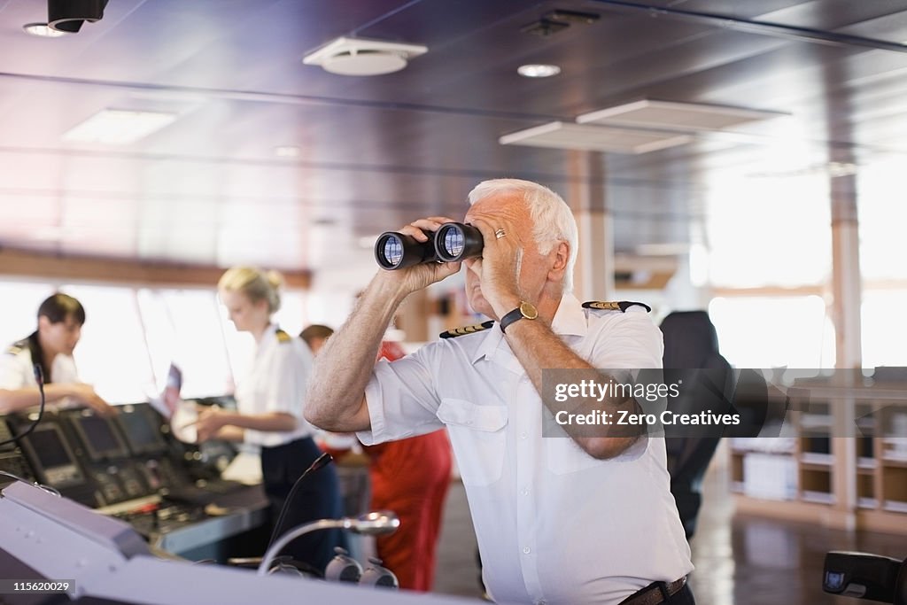 Captain on ship looking through a telescope