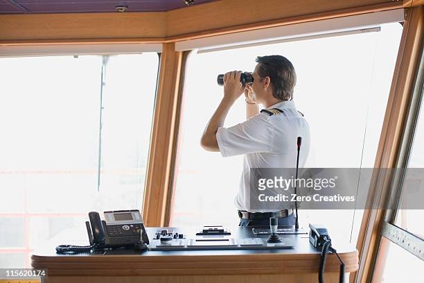 officer looking through binoculars - ship's bridge imagens e fotografias de stock