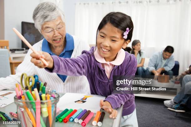 asian grandmother watching granddaughter drawing - kid with markers 個照片及圖片檔