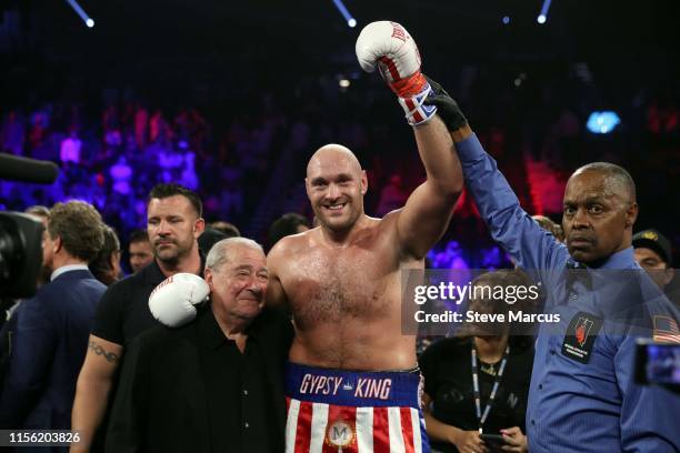 Tyson Fury poses with boxing promoter Bob Arum and referee Kenny Bayless after defeating Tom Schwarz during a heavyweight fight at MGM Grand Garden...