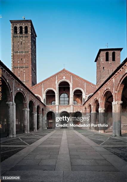 Italy; Lombardy; Milan; Sant'Ambrogio Basilica. Axial view exterior quadriporticus colonnade church saddle/sloping facade loggia arcades bell towers...