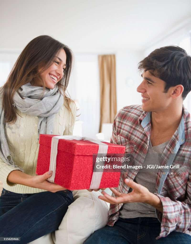 Woman handing husband Christmas gift