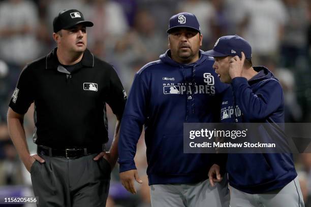 Manager Andy Green of the San Diego Padres is restrained from first base umpire Lance Barrett by Rod Barajas after being ejected in the sixth inning...