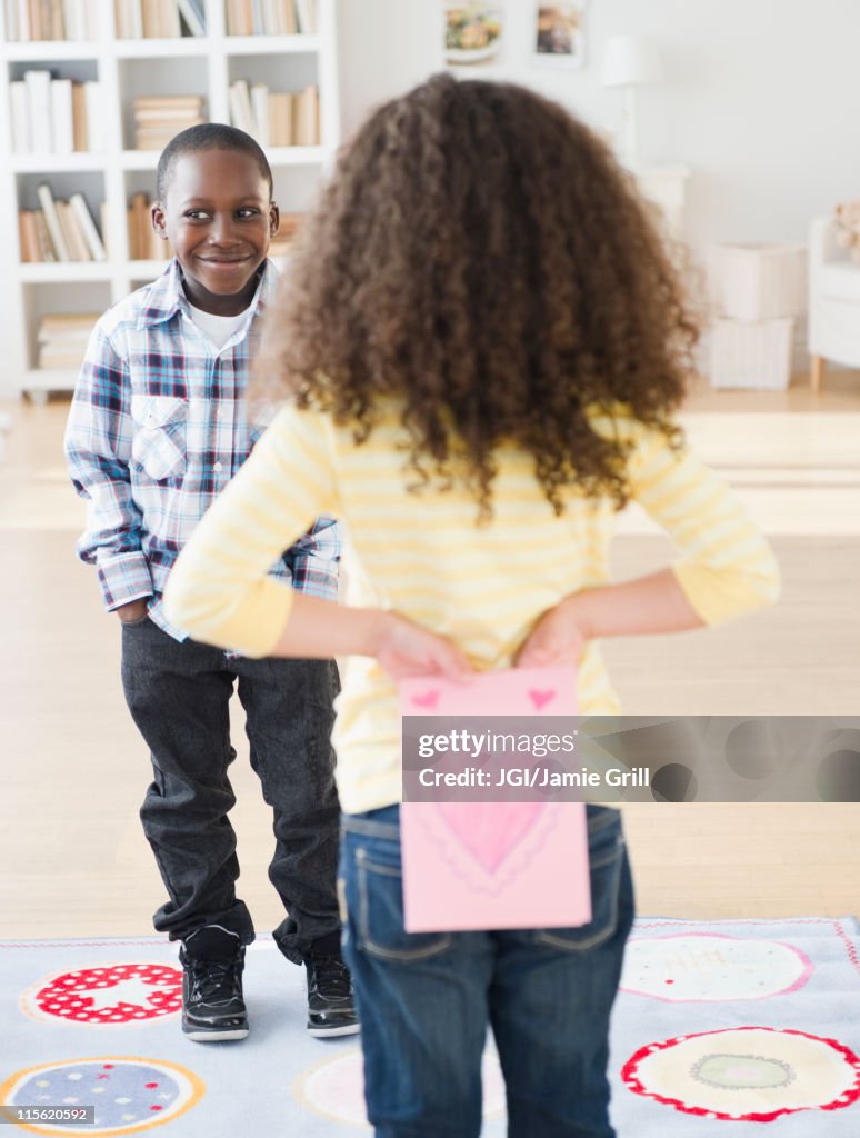 Girl holding Valentine card behind her back