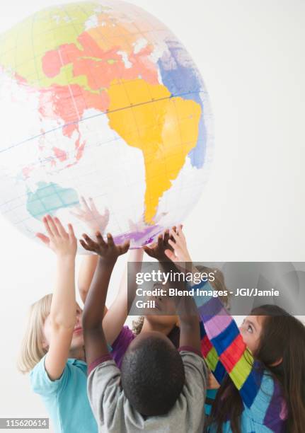 children lifting up plastic globe - equal arm balance stock-fotos und bilder