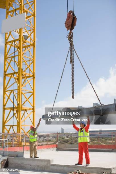 crane and workers on construction site - lowering stock pictures, royalty-free photos & images