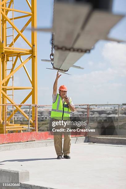 crane and older worker doing his job - crane steel beam stock pictures, royalty-free photos & images