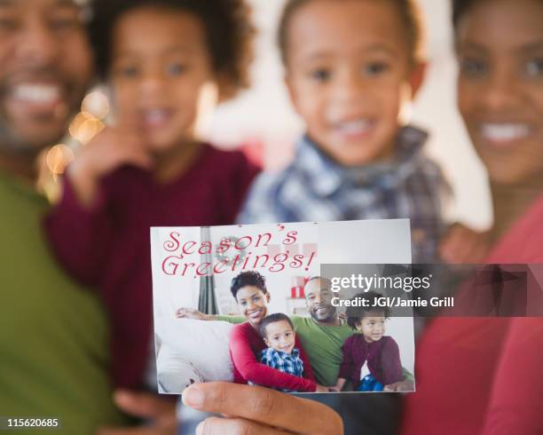 black family holding season's greetings photograph - weihnachten symbolbilder stock-fotos und bilder