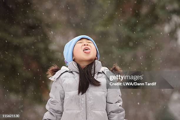 chinese girl catching snowflakes on her tongue - tongue stock pictures, royalty-free photos & images