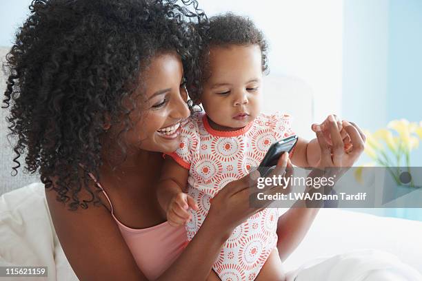 mother showing daughter cell phone - baby text stock pictures, royalty-free photos & images