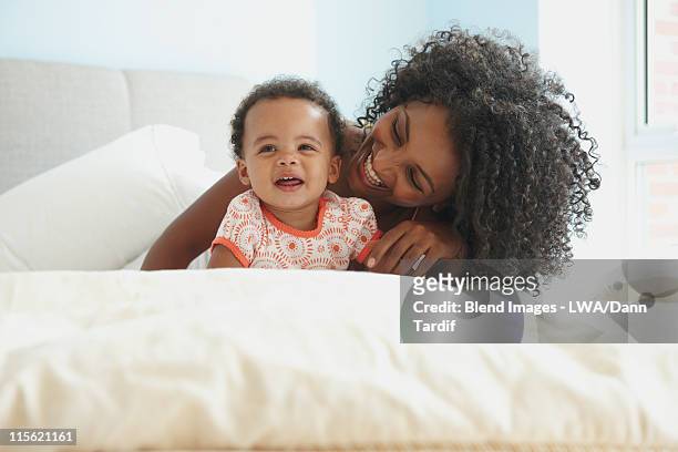 mother and daughter laying in bed - lwa dann tardif bed stock pictures, royalty-free photos & images