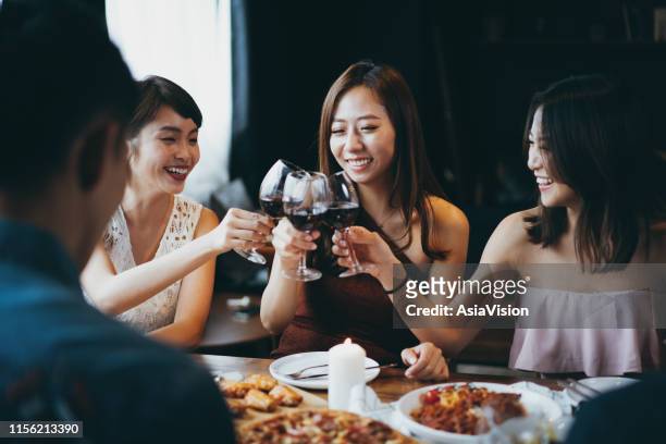 group of joyful young asian woman having fun and toasting with red wine during party - asia friend stock pictures, royalty-free photos & images